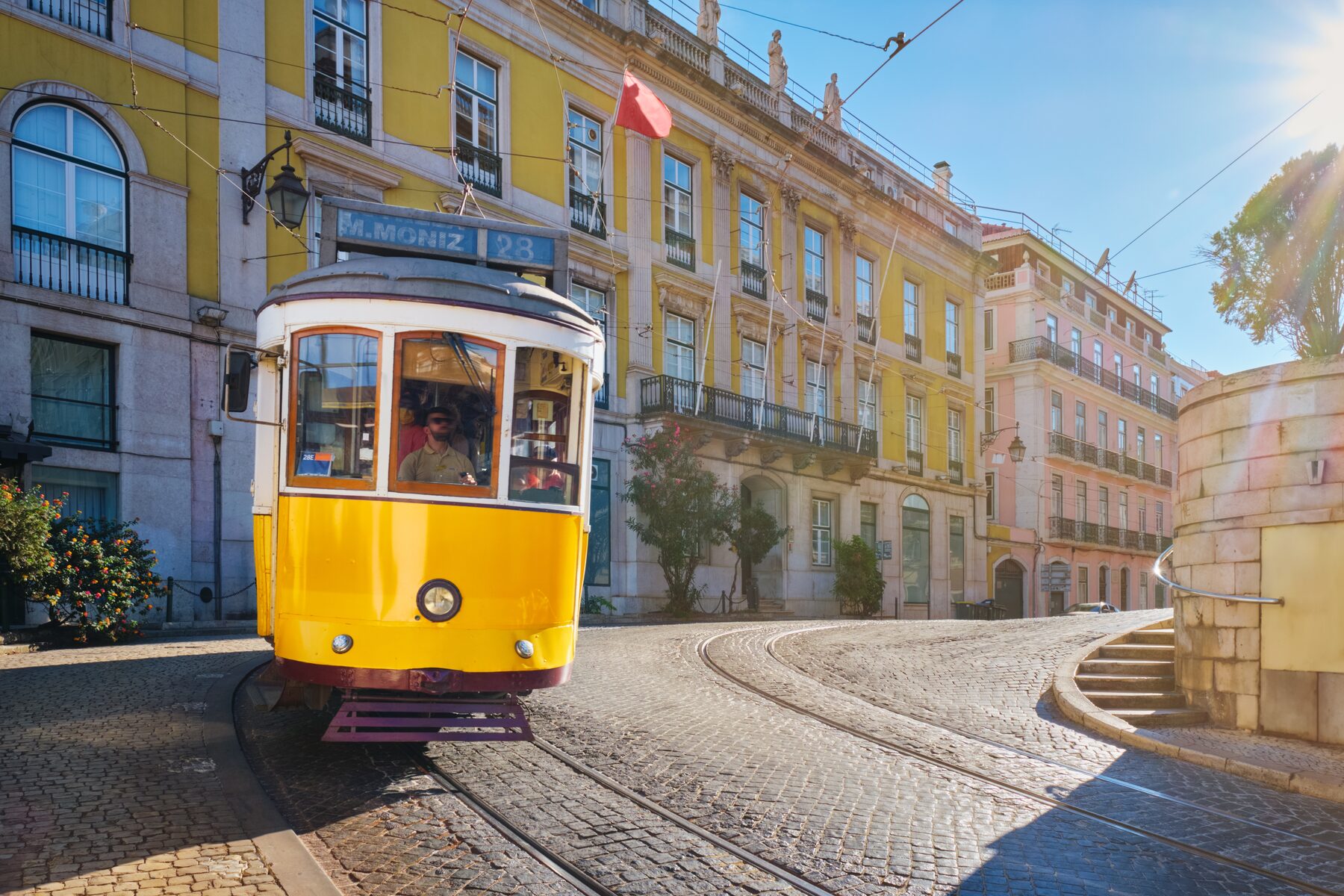 Gelbe Tram 28 in einer engen Straße von Lissabon